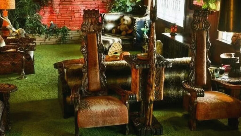 Jungle Room de Graceland, sala decorada com carpete verde, móveis de madeira esculpida e plantas tropicais na casa de Elvis Presley em Memphis