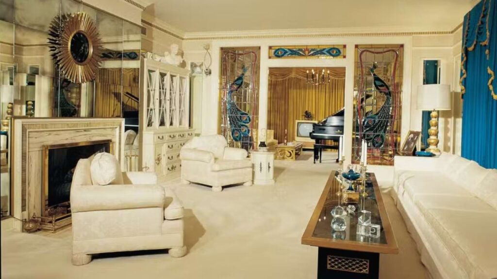 Sala de estar de Graceland com móveis brancos, lareira e piano