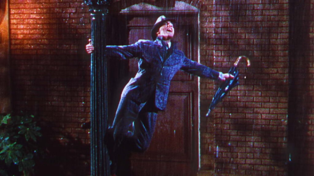 Cena clássica de Singin’ in the Rain (1952), musical famoso produzido durante a era do Technicolor em Hollywood.