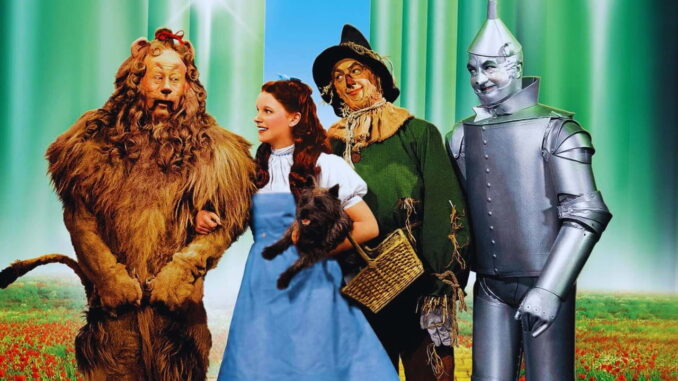Cena do filme The Wizard of Oz (1939) mostrando Dorothy, o Espantalho, o Homem de Lata e o Leão Covarde em cores vibrantes do Technicolor.